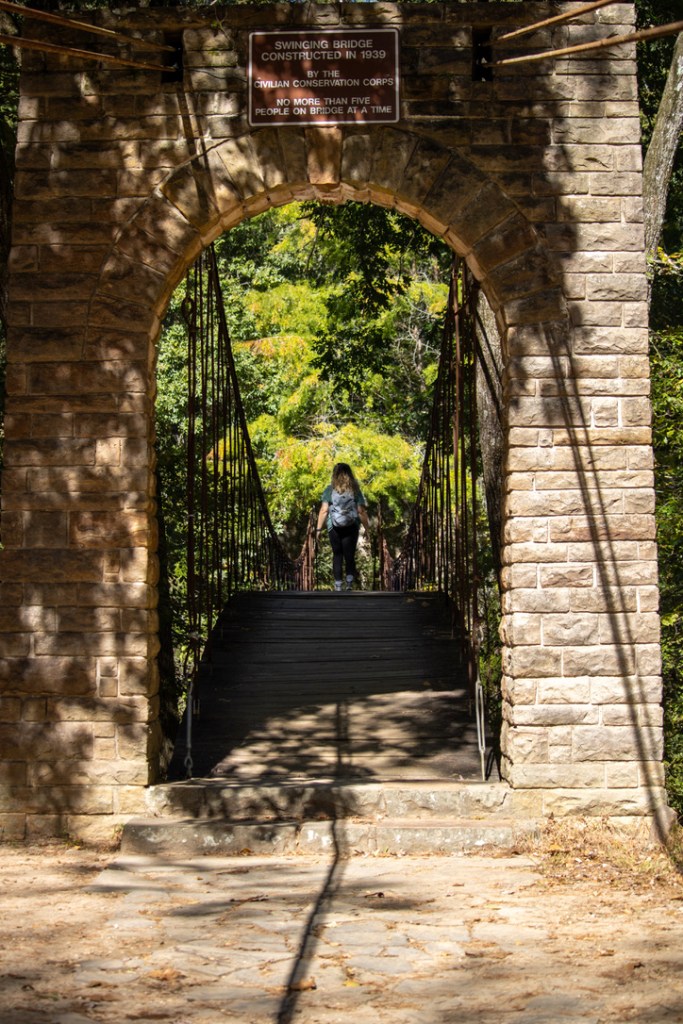 a girl walking across a bridge